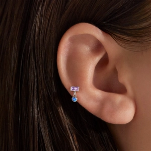 Detail of s925 silver ear stud with purple rectangle stone and blue round drop pendant