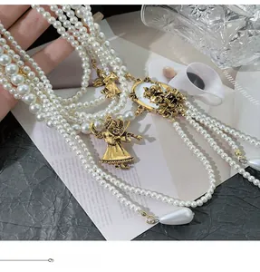 Detail of vintage layered pearl necklace with angel charms and portrait cameo pendant