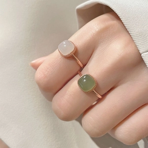 Retro square white and green jade rings set in rose gold finish on a model's hand