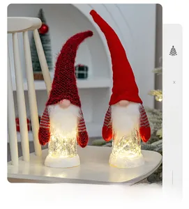 Detail von leuchtenden Weihnachts-Wichteln mit Strickmützen und LED-Schneesockel-Licht