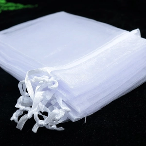 Detail of white organza gift bags showing transparent mesh texture and drawstring closure