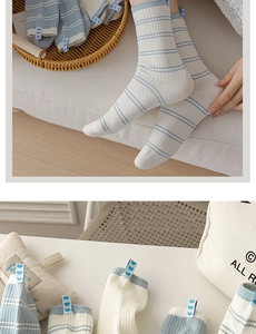 Detail of baby blue striped socks featuring a small heart fabric label and ribbed cotton texture