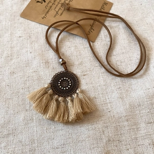 Bohemian geometric necklace with bronze tassel pendant and rhinestones on linen