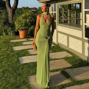 Detail of waist knot and pleated drapes on a green halter backless long dress