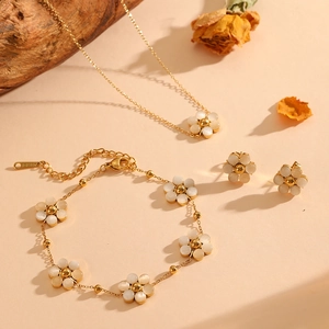 Detailed view of golden flower jewelry set with white opal and steel engraved tag