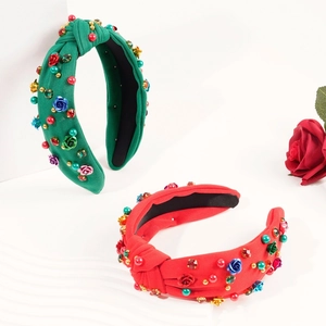 Detail of red and green knotted fabric headbands with beads and rose floral embellishments