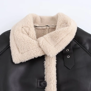 Detail of winter black leather jacket with beige faux shearling collar and button closure