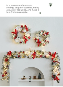 Detail of Christmas wreath with red bows and warm LED lights on a white fireplace