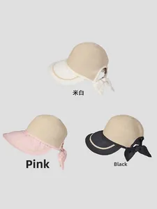 Detail of summer straw sun hats featuring elegant rear bows in beige, pink, and black colors