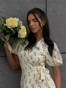 Detail of floral puff sleeve dress with yellow tulip print and side tie waist closure