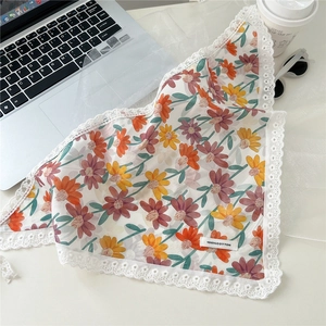 Detailed view of floral cotton headscarf with white lace trim and 100% cotton label