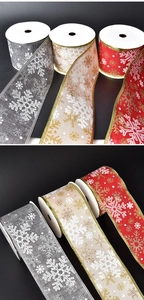 Detail of Christmas ribbon rolls in red, silver, and gold with snowflake patterns