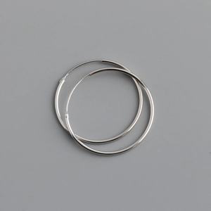 Detailed view of large polished S925 sterling silver hoop earrings with a minimalist design