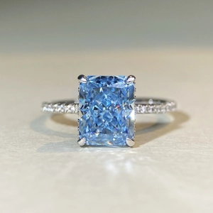 Macro view of blue radiant cut gemstone ring with sparkling micro-pave diamond band
