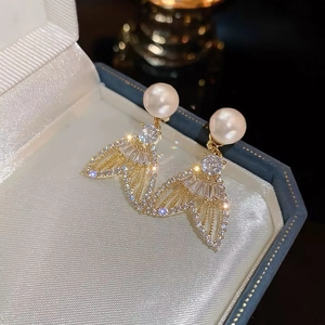 Vue détaillée de boucles d'oreilles perle sirène avec pavage dans un écrin à bijoux