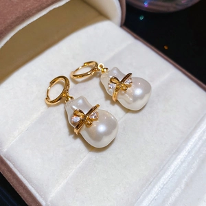 Détail des boucles d'oreilles nœud plaqué or 18k avec perles baroques et zircons