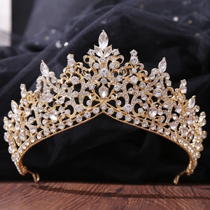 Close-up of luxury gold bridal crown with shimmering crystals on dark wooden texture