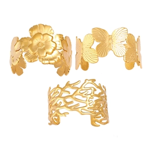 Golden cutout cuff bangles featuring floral, butterfly, and coral patterns on white background