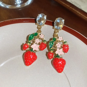 Detail of strawberry and flower drop earrings with red enamel and gold-plated finish