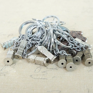 Macro shot of Big Ben metal keychains in silver and bronze colors on fabric background