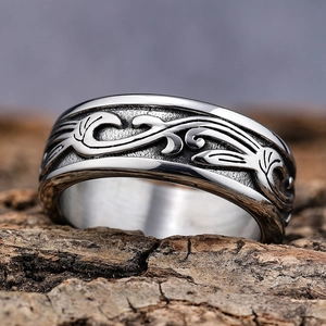 Vintage braided vine relief wide stainless steel ring displayed on rustic tree bark