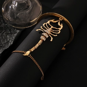 Exaggerated golden scorpion slave bracelet with sparkling rhinestones on black background