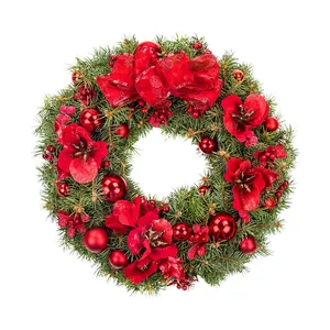 Classic Christmas wreath with green pine branches, red flowers and a large ribbon bow