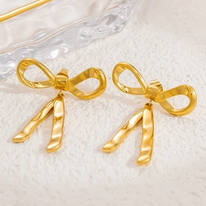Close-up of golden bow-shaped dangle earrings in 18k gold-plated stainless steel