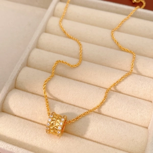 Macro shot of 18k gold plated cylinder pendant necklace with sparkling zircon accents