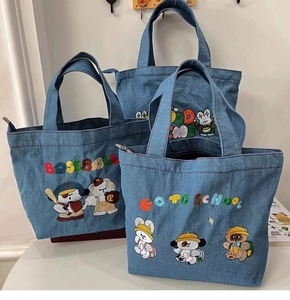 Close-up of embroidered cartoon characters on large capacity blue denim tote bags
