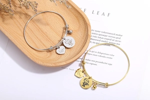 Detailed shot of adjustable stainless steel heart and astronaut charm bracelets