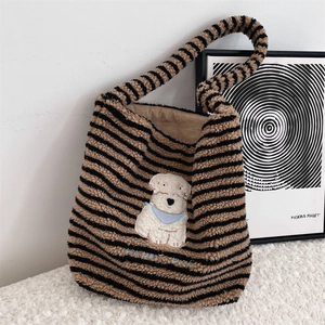 Close-up of fluffy striped tote bag with cute white dog embroidery and blue Happy Dog text