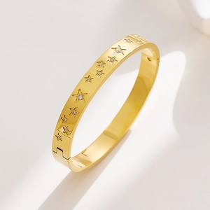 Close-up of golden stainless steel star bangle with sparkling zircon stone inlay