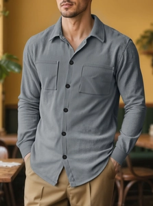 Detail of grey corduroy casual shirt featuring classic collar and symmetrical chest pockets