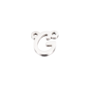 Close-up of polished silver stainless steel letter G connector pendant with double loops