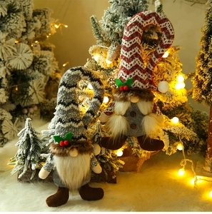 Close-up of plush Christmas gnomes with knitted hats and warm festive holiday lighting