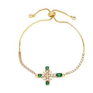 Adjustable gold cross bracelet with green zircon and pearls on a white background