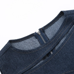 Close-up of dark blue denim top featuring contrast stitching and a silver metal zipper