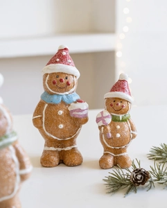 Detailed view of two festive resin gingerbread man figurines with glitter texture and pine cones