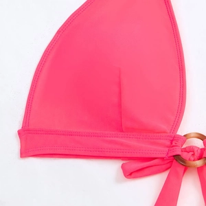 Detail of neon pink bikini top featuring high-quality stitching and marble resin ring decoration