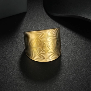 Geometric wide band 18k gold plated stainless steel ring with radial texture on black background