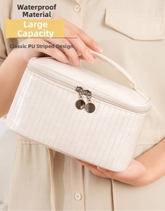 Detail of waterproof cream PU striped makeup bag with double zipper and top handle