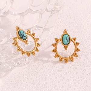 Detail of vintage bohemian earrings featuring oval turquoise stones and sunburst patterns