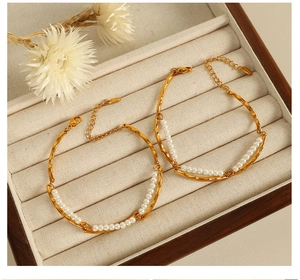 Detail of 18K gold-plated double-layer pearl bracelets in a beige velvet jewelry box