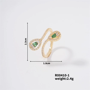Macro shot of gold butterfly ring with green stones and white diamonds showing dimensions