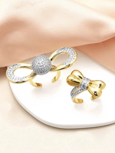 Detailed macro view of gold-plated bow rings with shimmering cubic zirconia accents