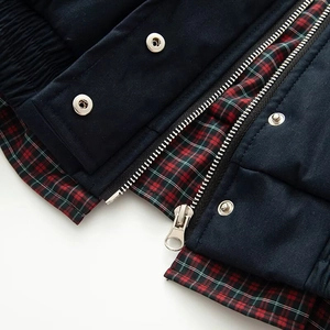 Detail der dunkelblauen Canvas-Jacke mit Karofutter und silbernem Metallreißverschluss