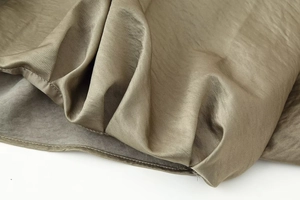 Macro shot of high-quality champagne satin fabric with smooth texture and fine stitching