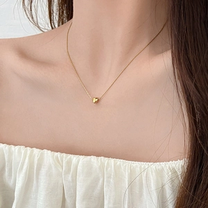 Elegant 18K gold-plated heart pendant necklace worn on a woman's collarbone
