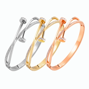 Detailed close-up of crossover nail bangles in silver, gold, and rose gold finish